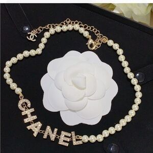 CHANEL White Pearl Necklace with Gold Lettering